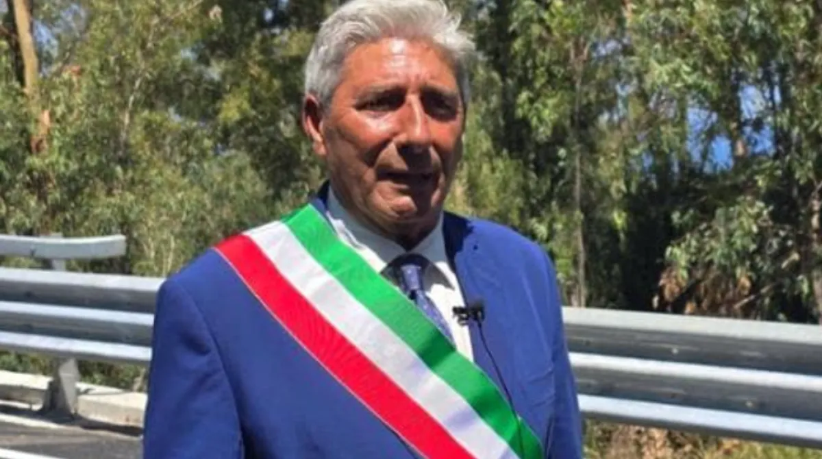Facciata di un municipio italiano con auto dei carabinieri, a illustrare l'inchiesta antimafia che ha portato all'arresto del sindaco di Spadafora
