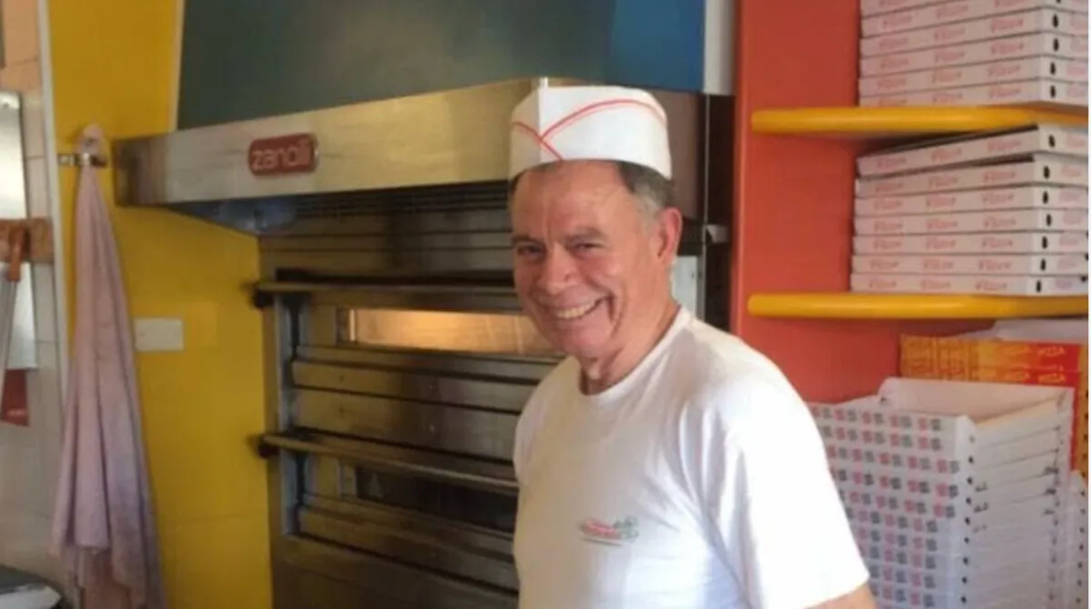 Vetrina di una pizzeria di sera in una via cittadina, a illustrare l'omicidio del titolare Raffaele Stipa a Reggio Emilia