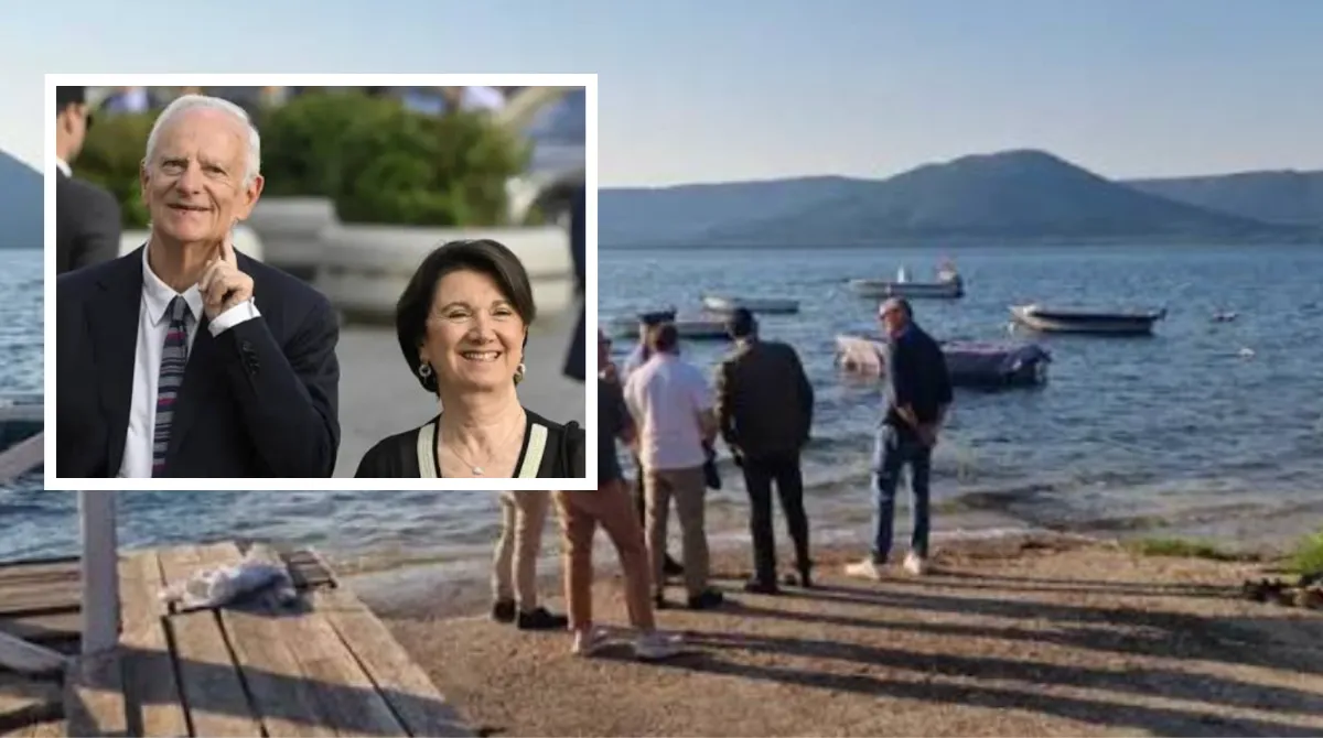 Lago all'alba con una piccola imbarcazione e mezzi di soccorso, a illustrare le ricerche del marito della ministra Roccella disperso in acqua